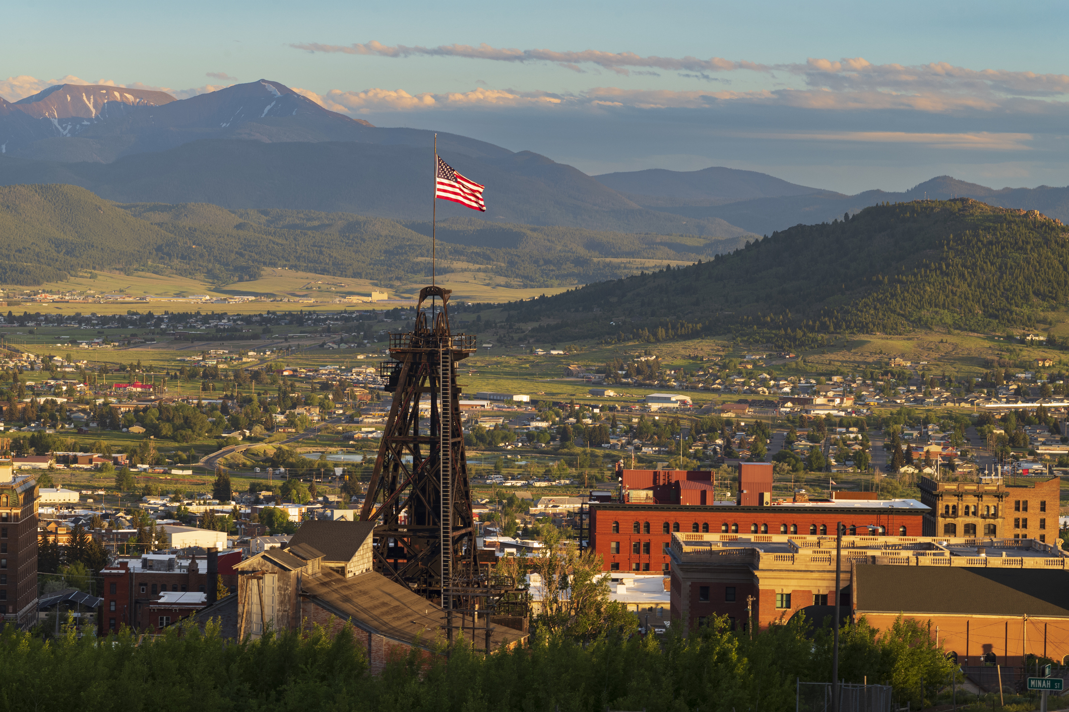 Headframe flying the American flag above Butte, Montana, with the Highland Mountains beyond